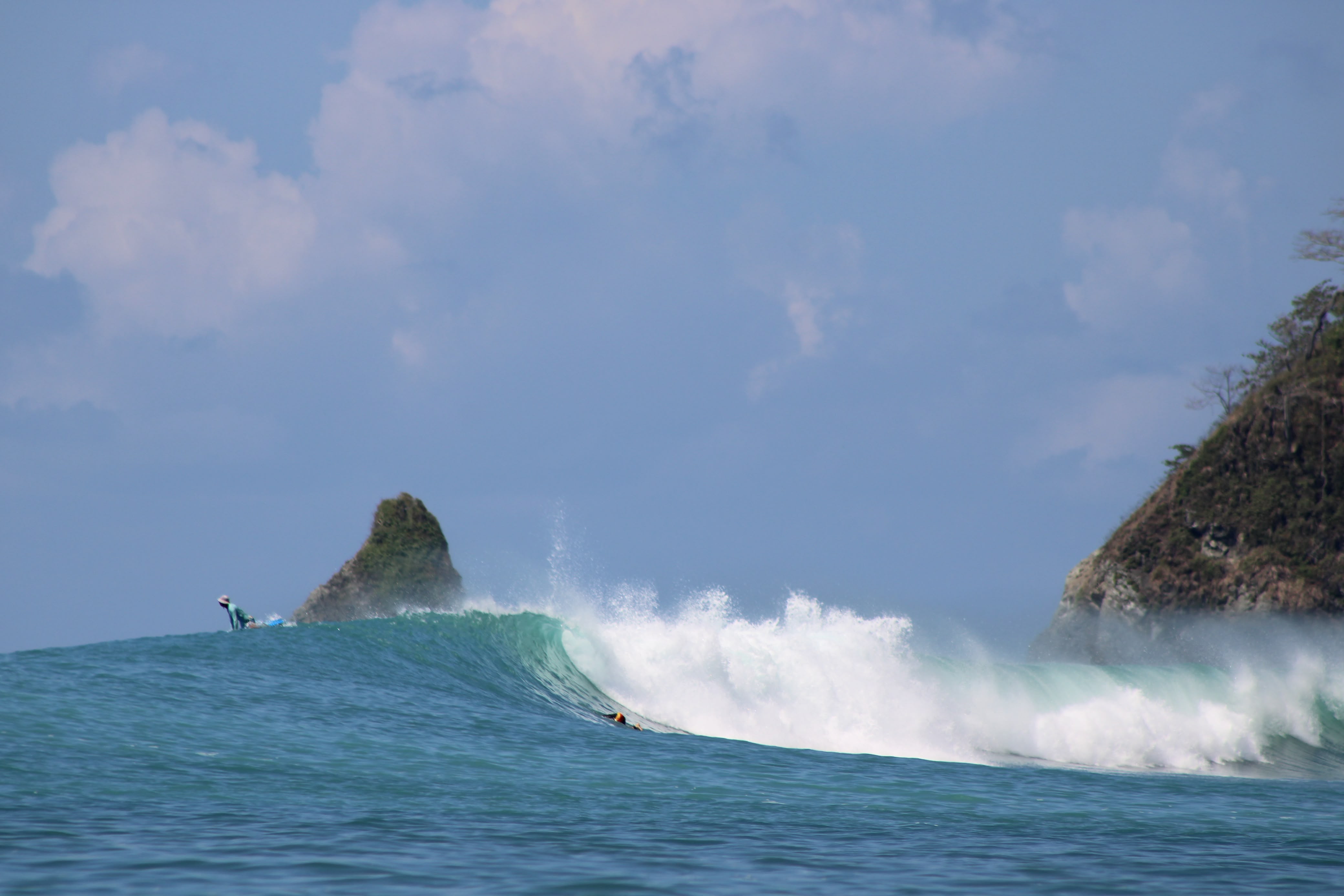 A surfer riding a right-hand point break at Matapalo across Golfo Dulce from Pavones, Costa Rica