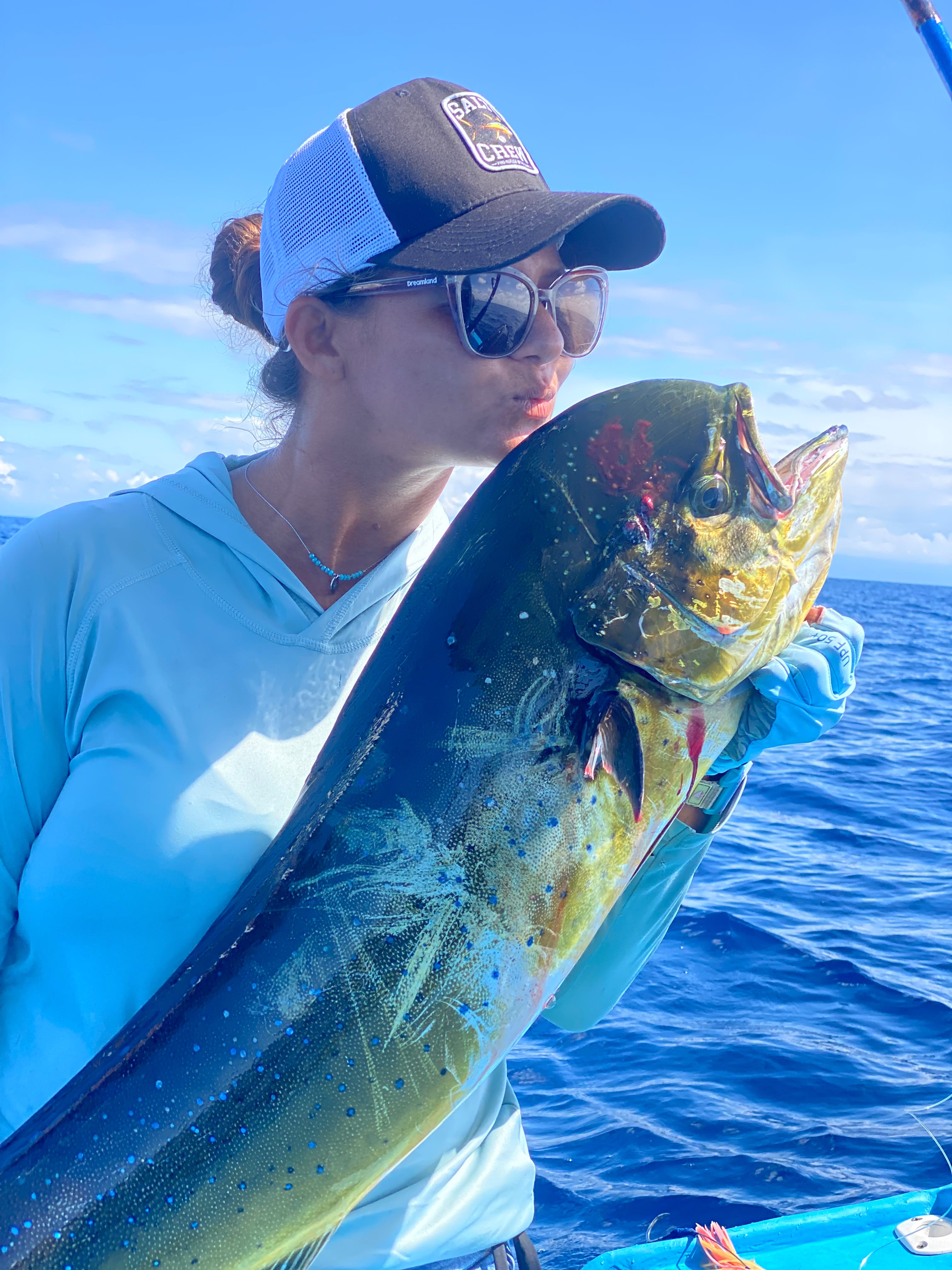 A guest holding a bright mahi-mahi caught on the crossing to Matapalo