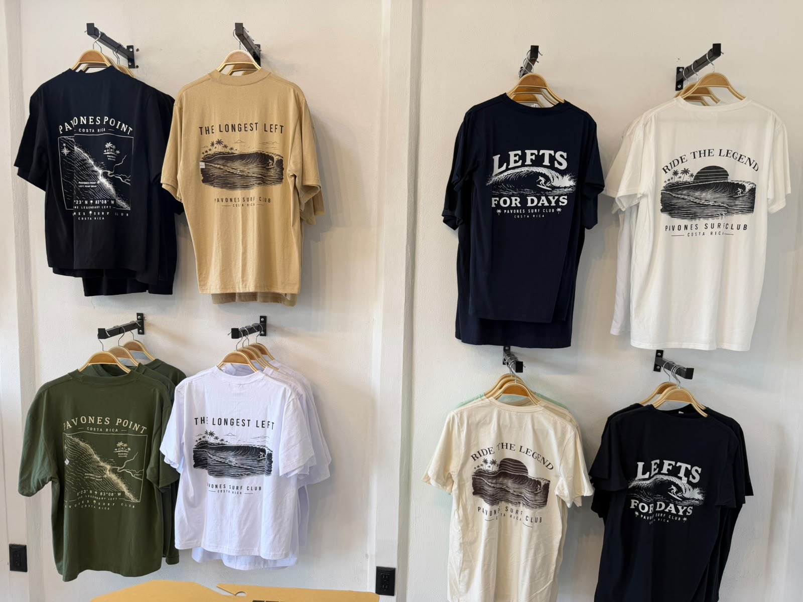 Wall of Pavones Surf Club t-shirts: Pavones Point, The Longest Left, Lefts For Days and Ride The Legend designs in navy, cream, olive and white